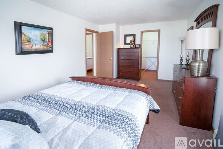 A bedroom with a bed, dresser, and nightstand.