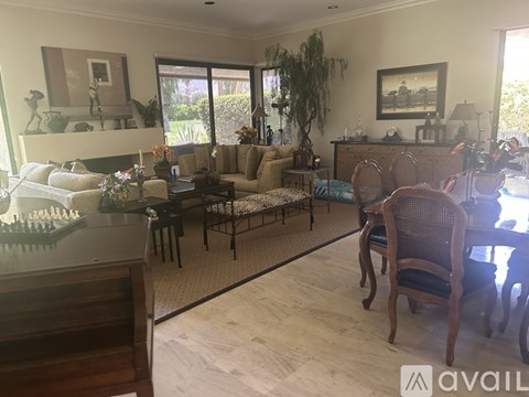 A living room with a couch, chairs, and a dining table.
