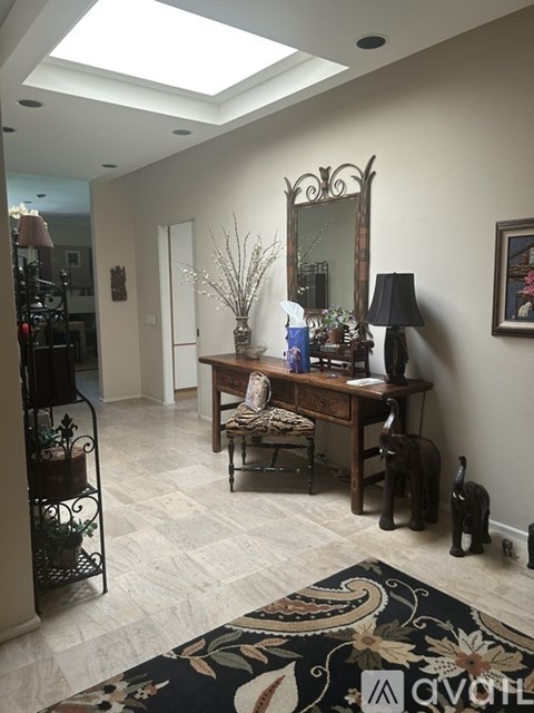 A room with a desk and a mirror on the wall.