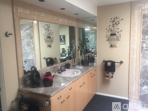 A bathroom with a sink, mirror, and a towel rack.