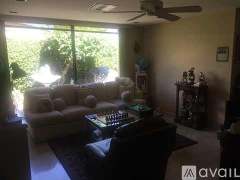 A living room with a large window and a white couch.