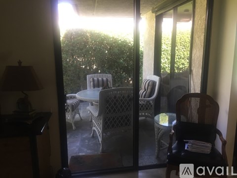 A patio with a table and chairs is visible through a glass door.