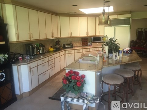 A kitchen with white cabinets and a wooden island.