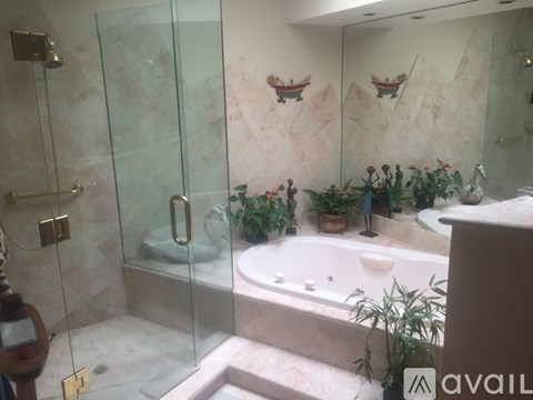 A bathroom with a glass shower door and a bathtub.