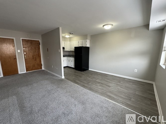 A room with a grey carpet and a black cabinet.
