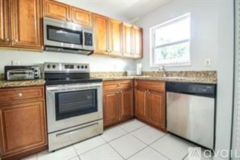 A kitchen with wooden cabinets and stainless steel appliances.