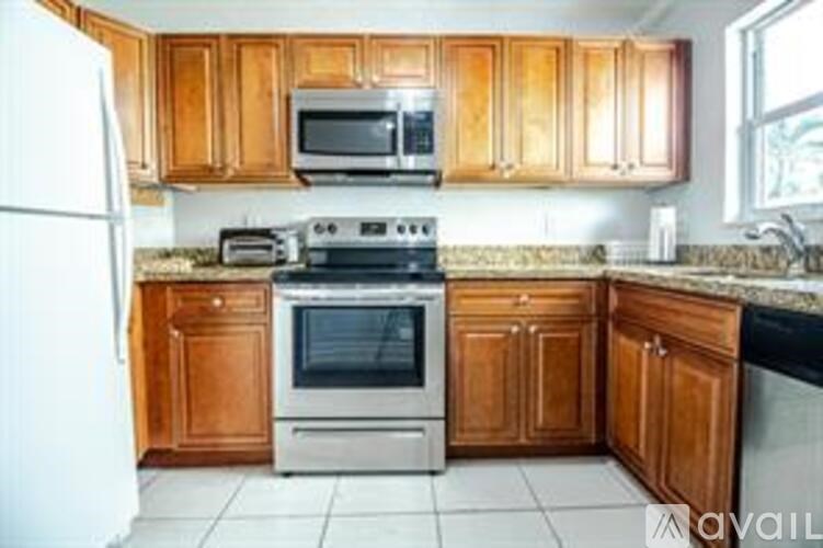 A kitchen with wooden cabinets and a white refrigerator.