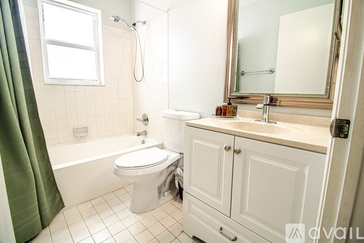 A white toilet sits in a bathroom next to a white sink.