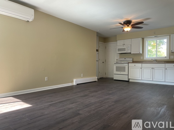 A kitchen with white cabinets and appliances is available for rent.