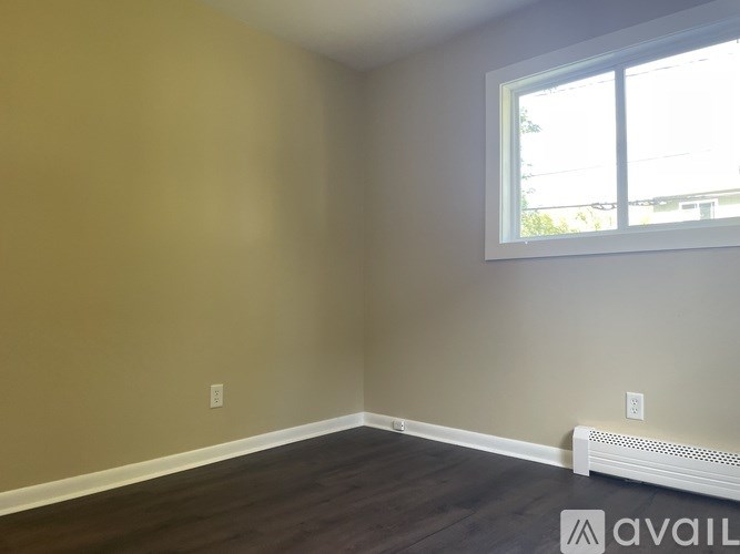 A room with a window and a wall with two switches.