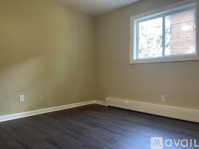 A room with a window and a wall socket.