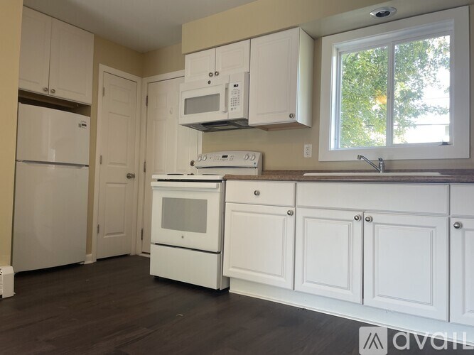 A kitchen with white appliances and cabinets.