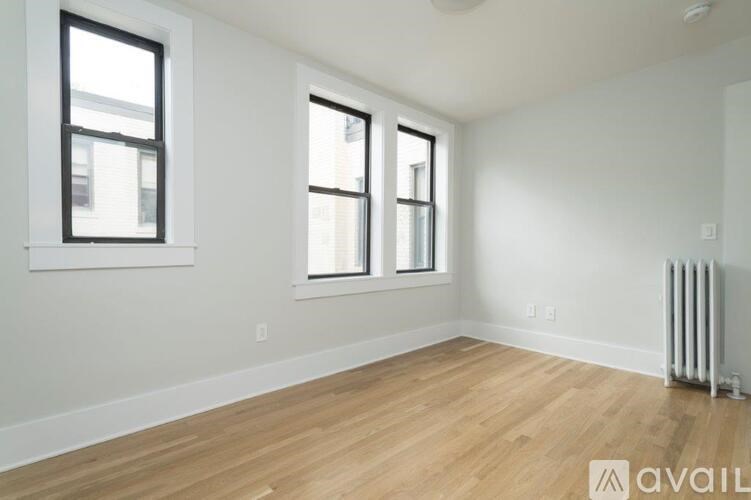 A room with wooden floors and two windows.