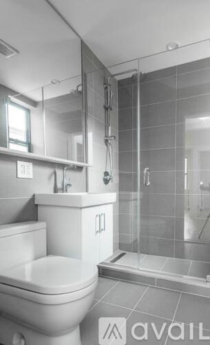 A bathroom with a toilet, sink, and walk-in shower.