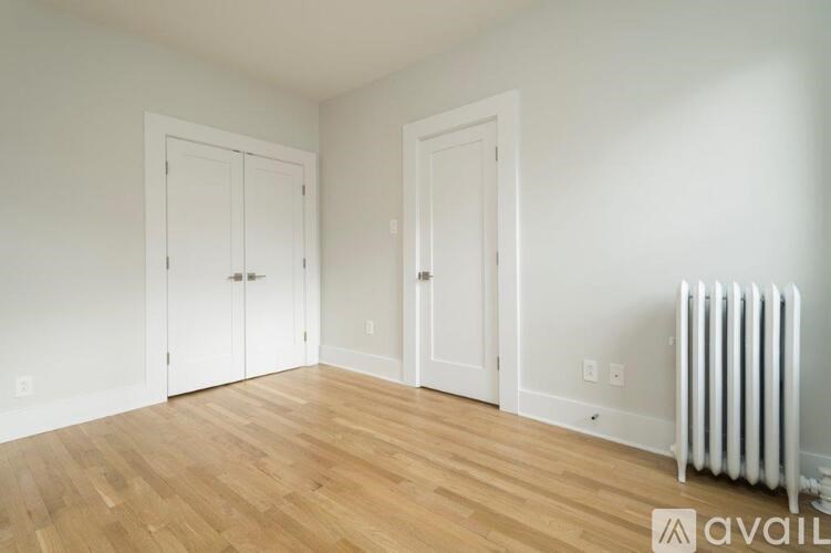 A room with wooden floors and two white doors.