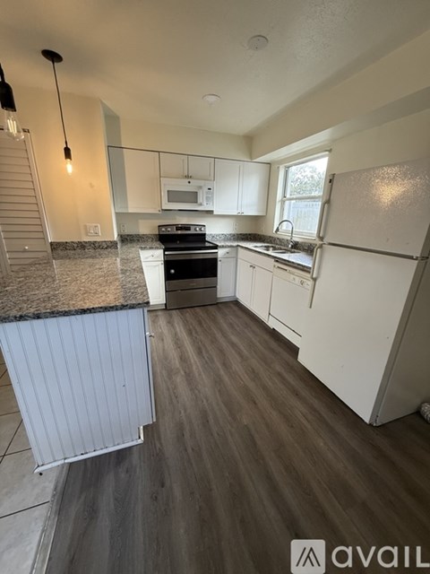 A kitchen with white cabinets and a black stove top oven.