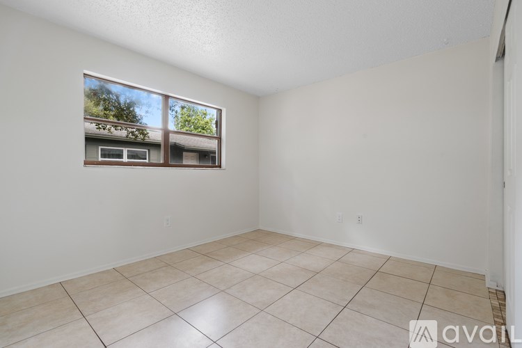 A room with a ceiling fan and tile flooring.