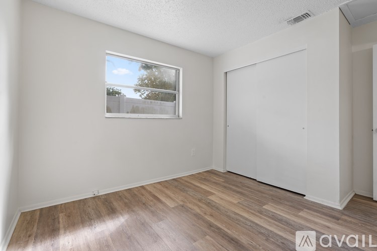 A backyard with a brick patio and a wooden fence.