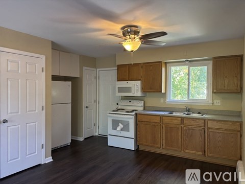 A kitchen with white appliances and wooden cabinets.