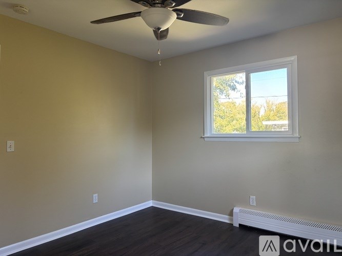 A room with a ceiling fan and a window.