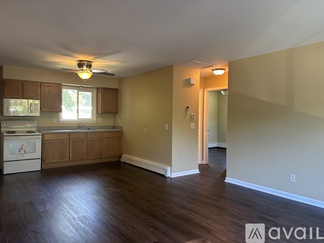 A kitchen with wooden floors and a ceiling fan.