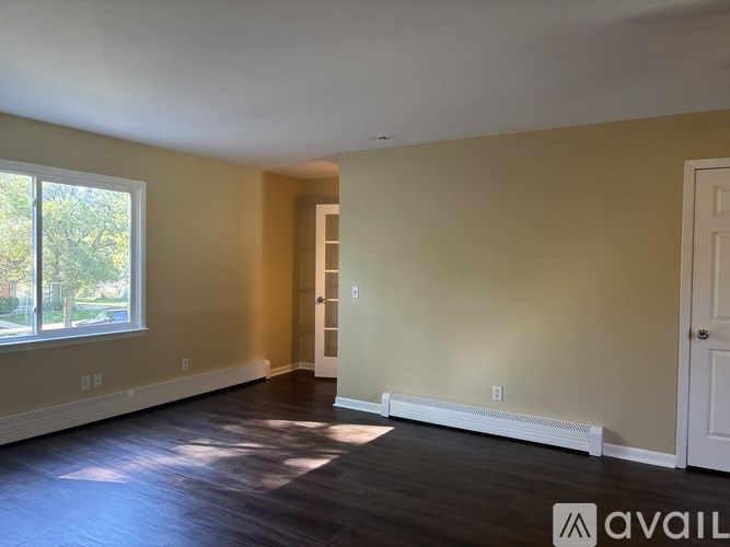 A room with a window and a door is available for rent.