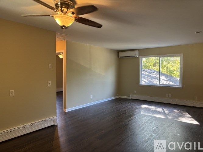 A room with a ceiling fan and a window.