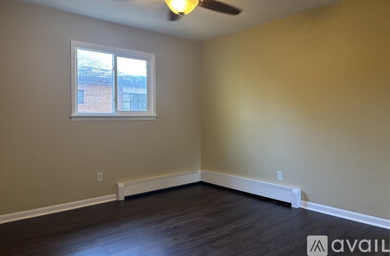 A room with a window and a ceiling fan.