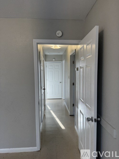 A hallway with white doors and a light on the ceiling.