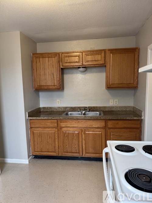 A kitchen with wooden cabinets and a white stove.