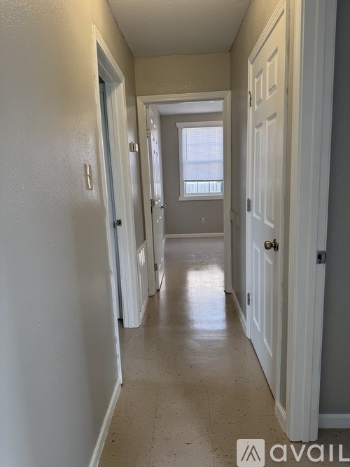A long hallway with white doors on both sides.