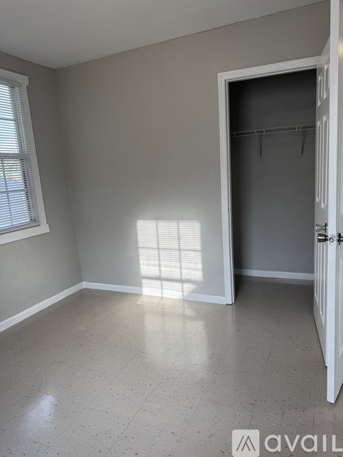 A room with a white door and a window with blinds.
