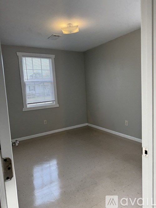 A room with a window and a white door.