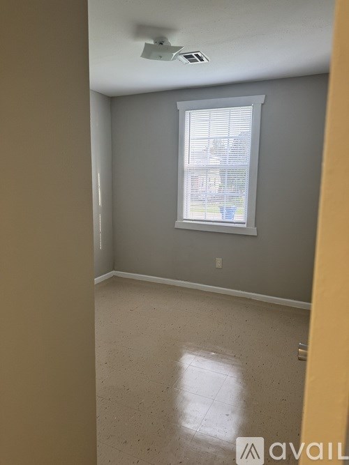 A room with a window and a ceiling fan.