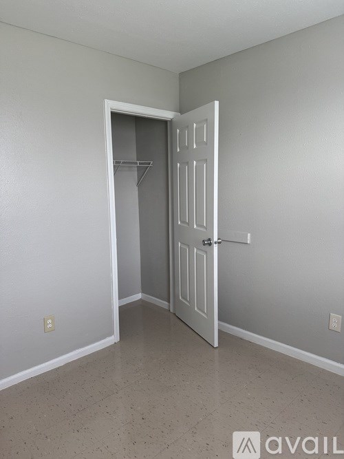 A room with a white door and a white shelf.
