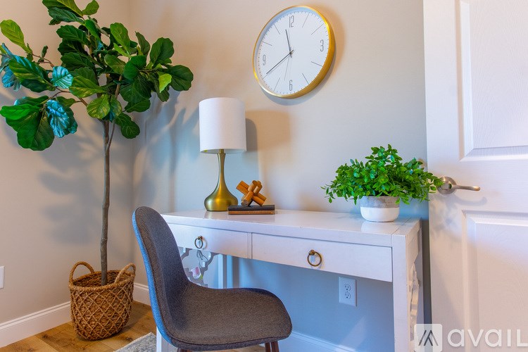 A desk with a chair and a clock on the wall.