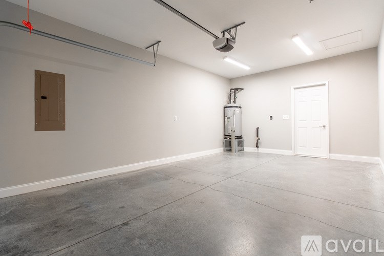 A large empty room with a door on the right and a brown door on the left.