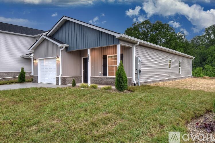 A modern house with a grey roof and a white garage door.
