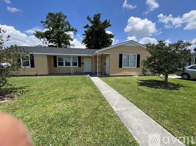 A mobile home with a concrete walkway leading to the front door.