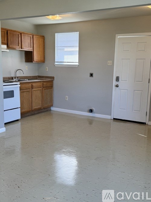 A kitchen with white appliances and wooden cabinets.