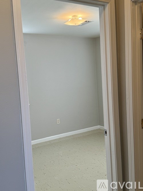 A room with a light on the ceiling and a door on the right.