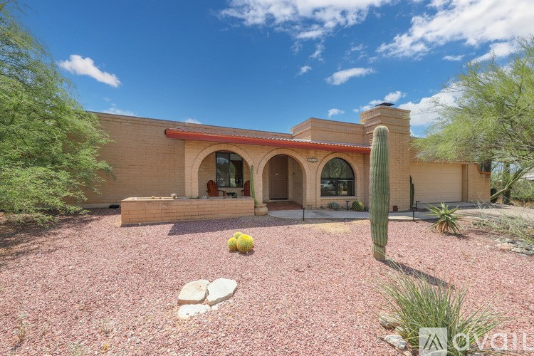 A house with a red roof and a cactus in front.