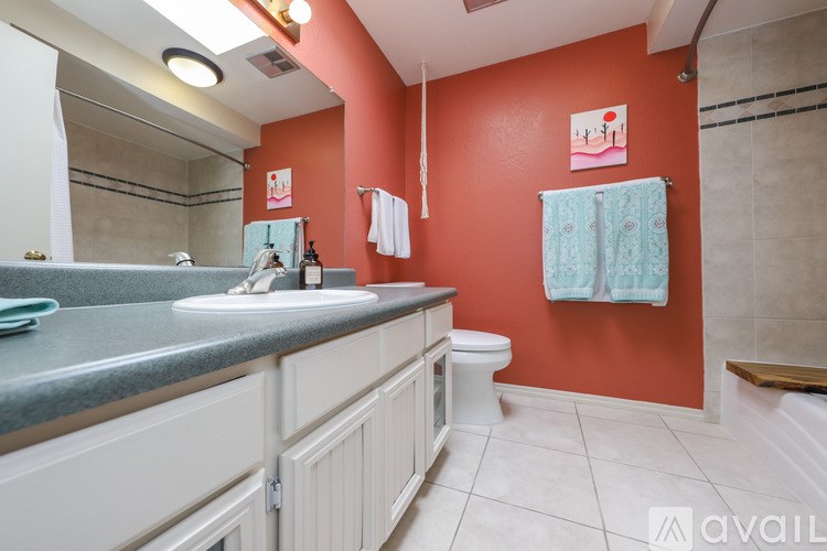 A bathroom with a red wall and a white toilet.