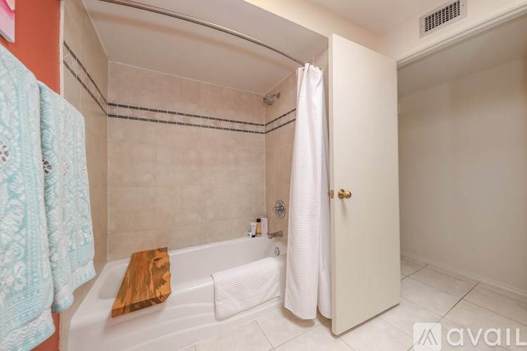 A bathroom with a bathtub and a towel rack.