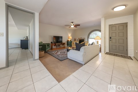 A living room with a white couch and a television.