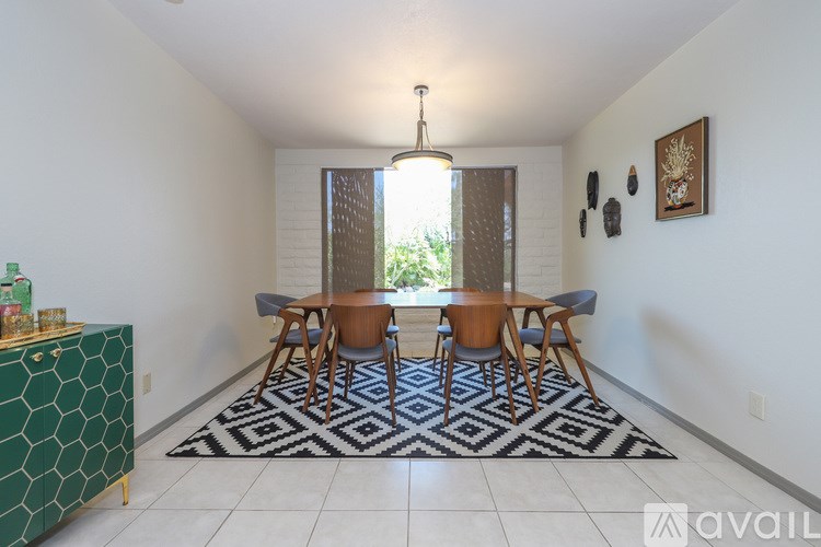 A dining room with a hexagonal green table and chairs.