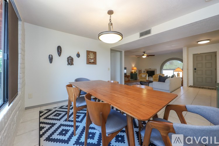 A dining room with a wooden table and chairs.
