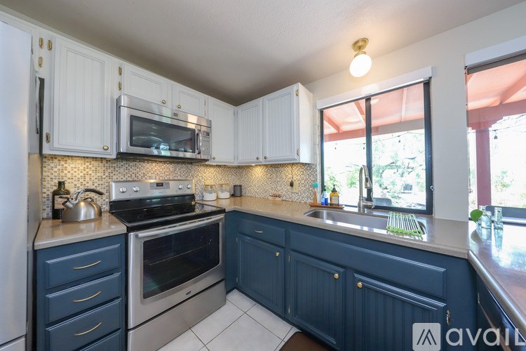 A kitchen with white cabinets and a blue counter.