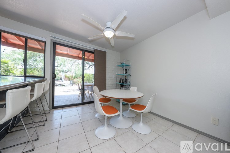 A dining room with a white table and chairs.