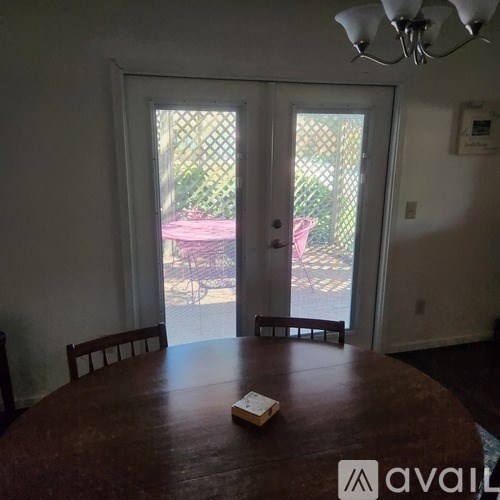A dining room with a wooden table and chairs and a book on it.